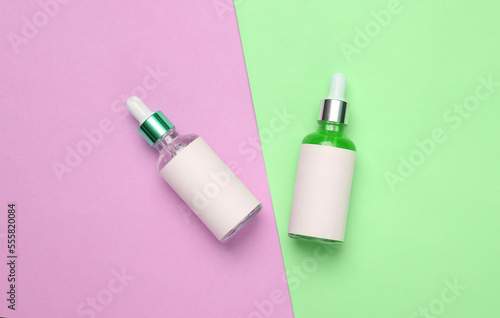 Serum bottles on colored background. Mockup for design