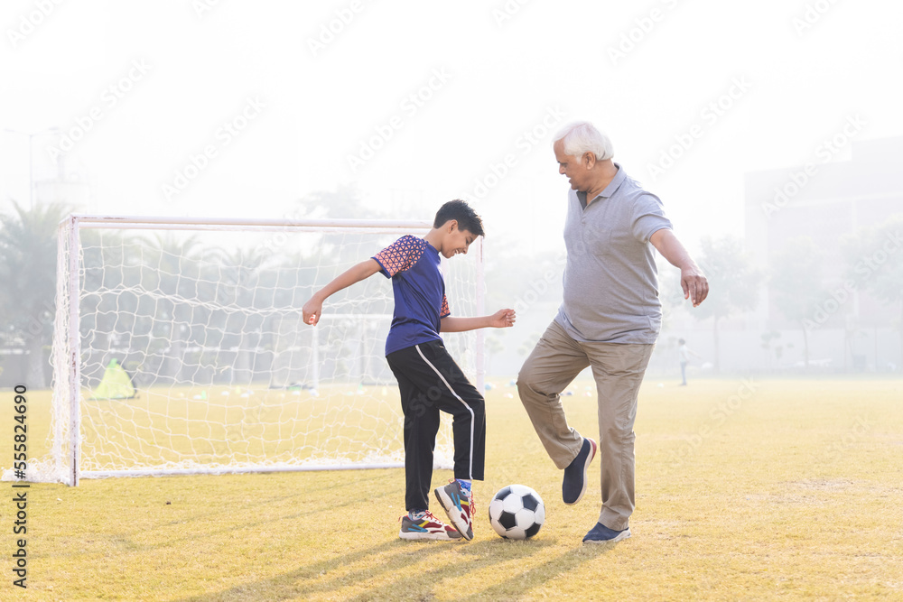 Family playing football outdoors and boy attacking his grandfather.