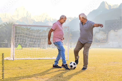 Senior friends playing football together.