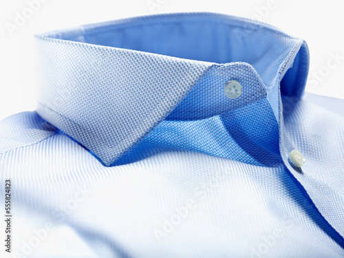 Detail of collar of blue shirt on white background in studio
