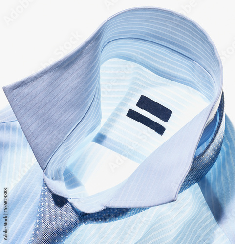 Detail of a blue shirt with tie on white background, studio shot photo