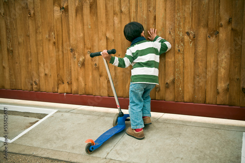 Boy Peeking Through Fence