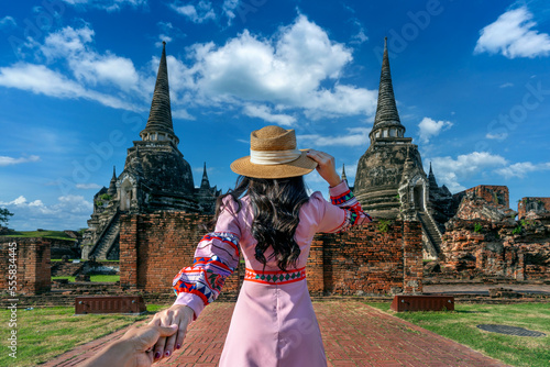 Canvas Print Woman holding man's hand and leading him to Ayutthaya Historical Park, Wat Phra Si Sanphet temple in Thailand