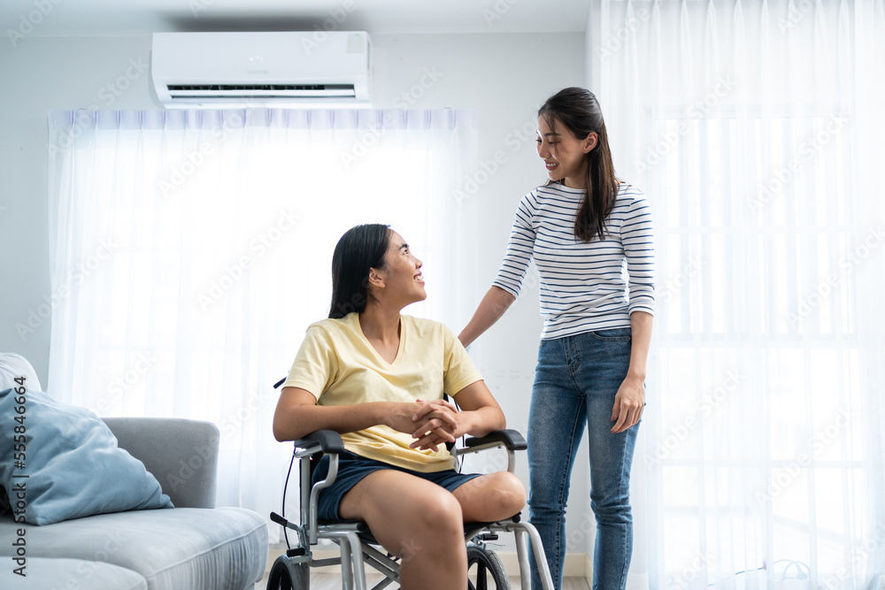 Asian young woman talking to female amputee friend sit on wheelchair. Asian young woman talking to female amputee friend sit on wheelchair.