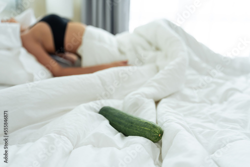 Close up of cucumber foods for erotic sex education on bed in bedroom. 