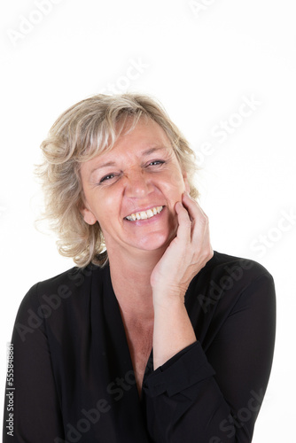 senior woman blonde 60 years hand under chin in white studio background