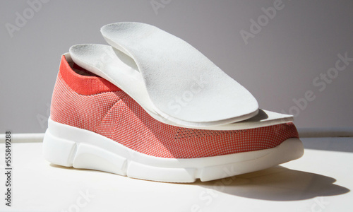 Leather orthopedic insoles located on sport shoe with orthopedic