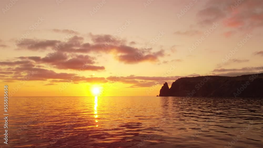Aerial view on sunset over calm sea and volcanic rocky shores. Small waves on water surface in motion blur. Nature summer ocean sea beach background. Nobody. Holiday, vacation and travel concept Aerial view on sunset over calm sea and volcanic rocky shores. Small waves on water surface in motion blur. Nature summer ocean sea beach background. Nobody. Holiday, vacation and travel concept