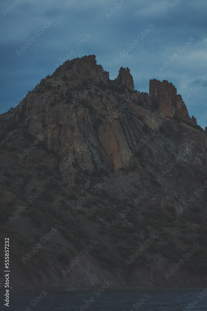 Steep Karadag mountain on coast landscape photo. Beautiful nature scenery photography with evening sky on background. Idyllic scene. High quality picture for wallpaper, travel blog, magazine, article Steep Karadag mountain on coast landscape photo. Beautiful nature scenery photography with evening sky on background. Idyllic scene. High quality picture for wallpaper, travel blog, magazine, article