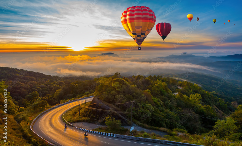 Colorful hot air balloons flying over mountain and sea of misty morning in sunrise at Dot Inthanon in Chiang Mai, Thailand..One of the important landmarks of Thailand.