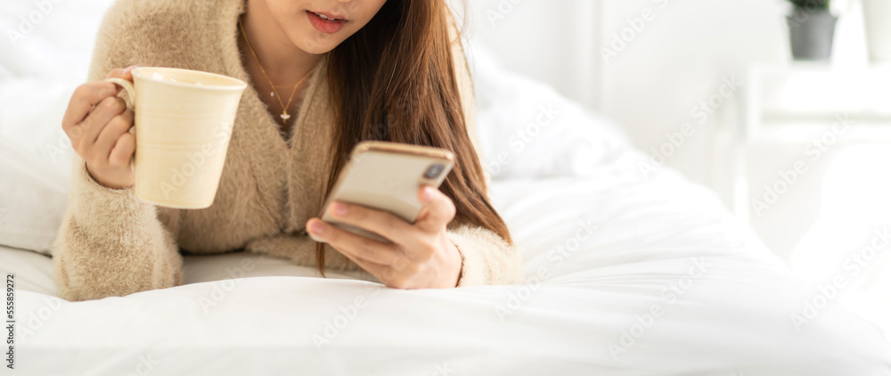 Portrait of smiling happy beautiful asian woman relaxing using digital smartphone.Young asian girl looking at screen typing message and playing game online or social media at home