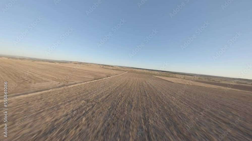 FPV drone flying fast across Artesa De Lleida grassland speeding past pilot in open meadow FPV drone flying fast across Artesa De Lleida grassland speeding past pilot in open meadow