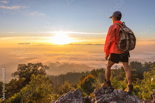 Hiker standing on top mist mountain sunrise background. Hiker men's hiking living healthy active lifestyle.