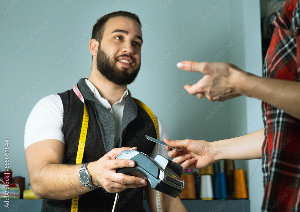 Fototapeta premium Customer paying with credit card in tailor atelier
