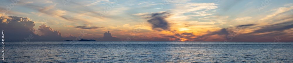 Fototapeta premium dramatic clouds during sunset over the sea, panoramic view