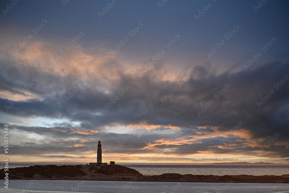 Beautiful sunset on the beach of Los Caños de Meca with the background of the Trafalgar Lighthouse, Barbate, Cadiz