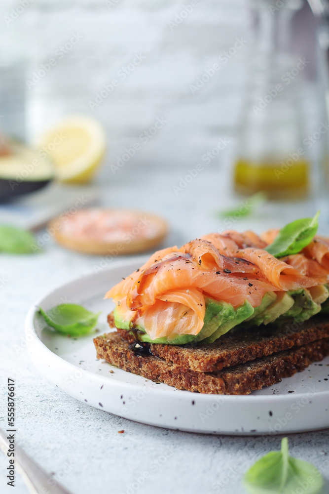 A rye bread sandwich with avocado and salmon	