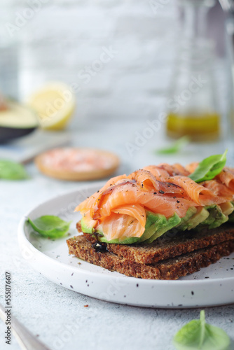 A rye bread sandwich with avocado and salmon 