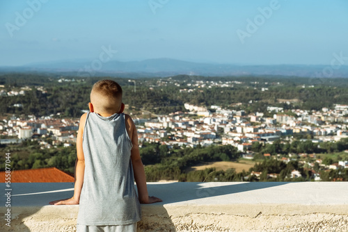 Distant view across the expanse of Santarem region with the Church of Ourem in the foreground, Portugal. Child looking on view photo