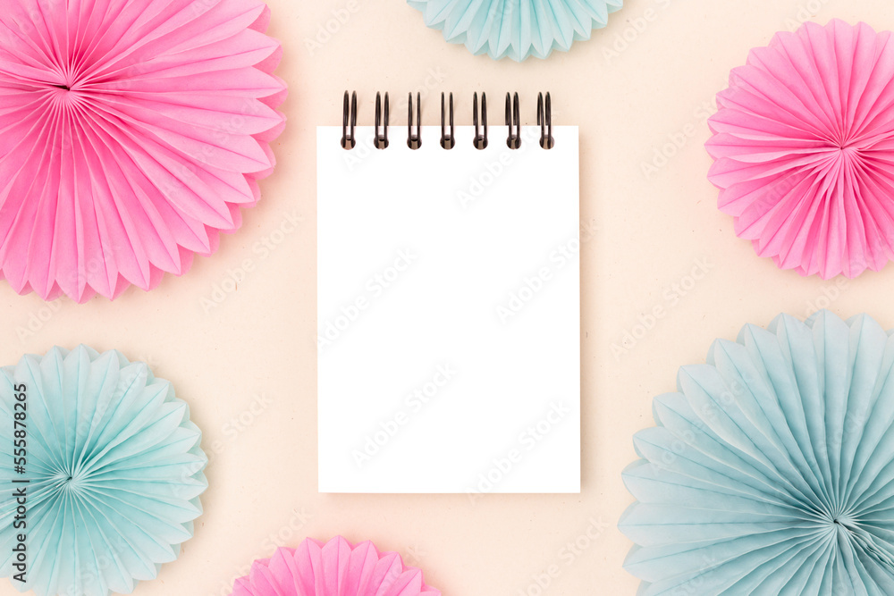 Notepad mockup and tissue paper fans on a beige background.