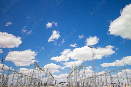 power plant and transformer towers close-up in the steppe, against the blue sky