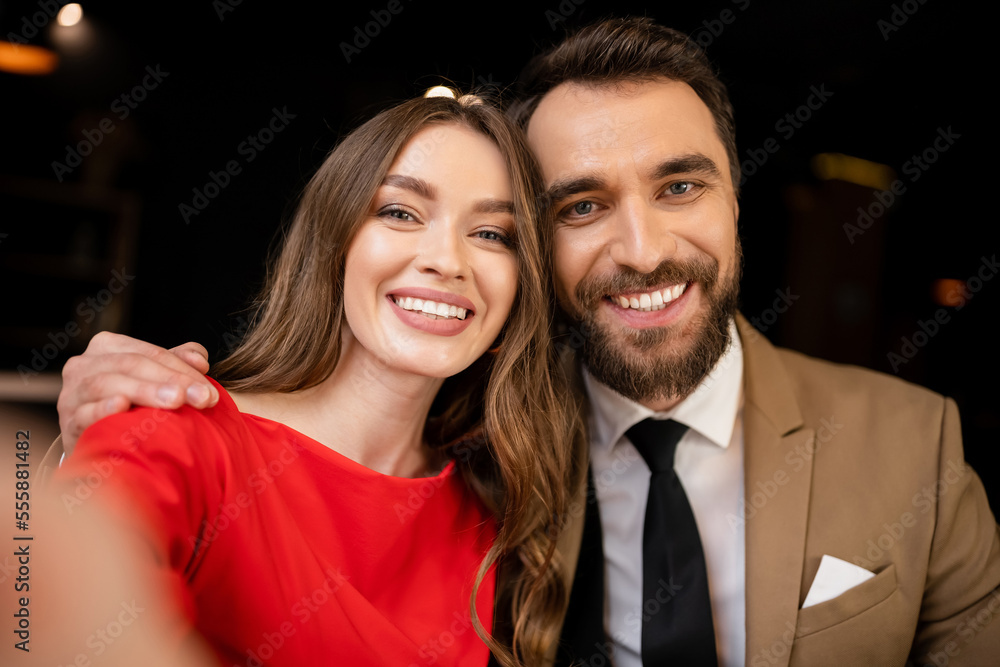 portrait of cheerful young couple in festive attire looking at camera portrait of cheerful young couple in festive attire looking at camera
