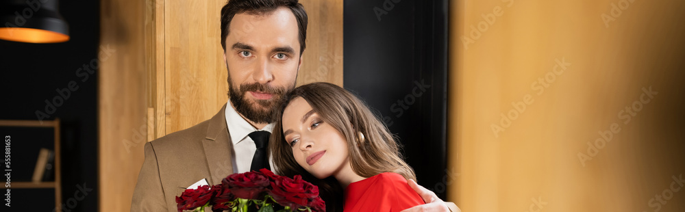 young woman looking at red roses and leaning on boyfriend on valentines day, banner young woman looking at red roses and leaning on boyfriend on valentines day, banner