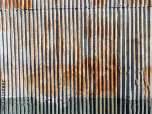 Pared de chapa metàlico acanalado de un galpòn de cereales, antiguo y oxidado en el exterior, forma un original y bello diseño industrial para fondos texturizados