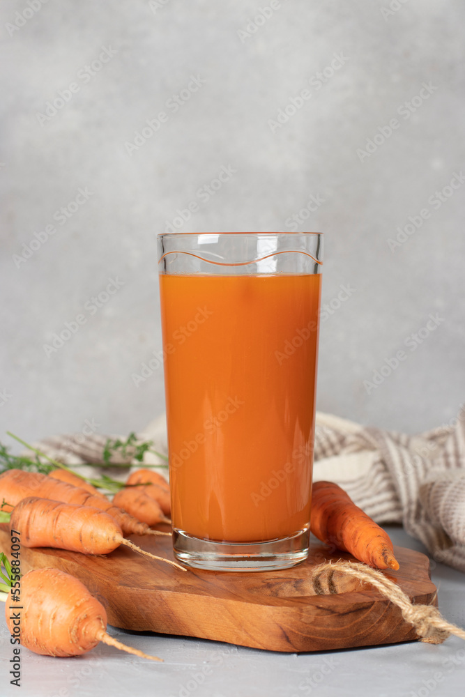 Fresh carrot juice in tall glass on gray background. Concept of healthy eating and dieting Fresh carrot juice in tall glass on gray background. Concept of healthy eating and dieting