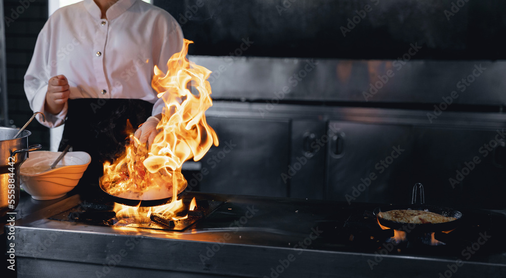 Process professional chef and fire. Woman cooking food vegetables open ...