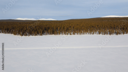 frozen lake with forest and mountain landscape in finnish lapland during winter