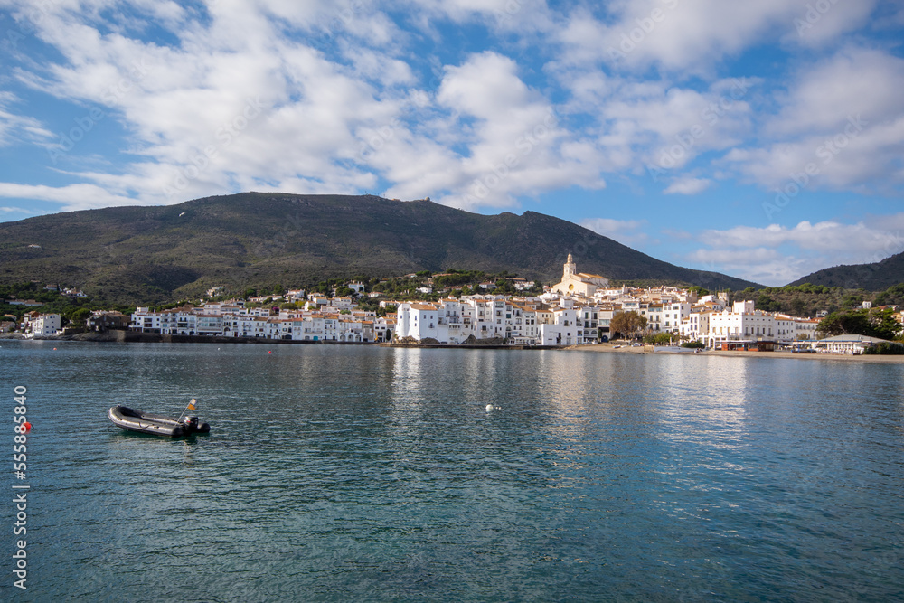Obraz premium Lancha motora en medio del tranquilo mar azul del pequeño pueblo pesquero de Cadaqués con las verdes montañas de fondo.