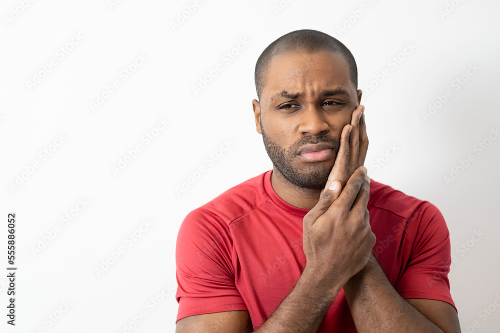 Dental problems. Portrait of darkskinned man pressing irritated cheek