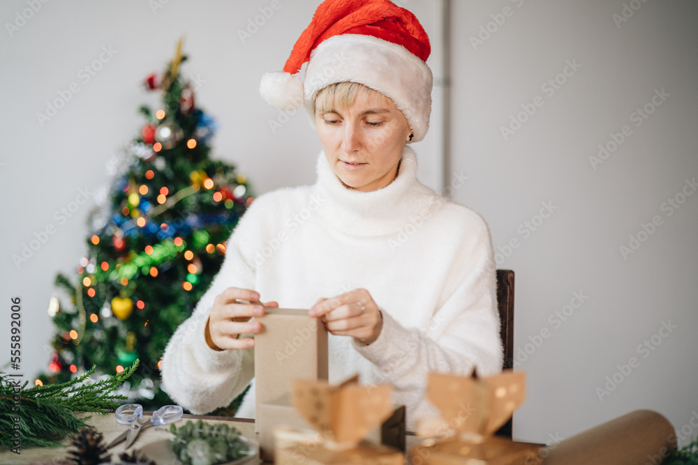 Woman wrapping christmas presents with eco materials at home Woman wrapping christmas presents with eco materials at home