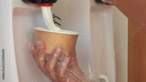 The plate is filled with ice cream. Close-up filling of plate with ice cream. Ice cream in a plate. 4K Slow Motion. A worker fills a plate with ice cream