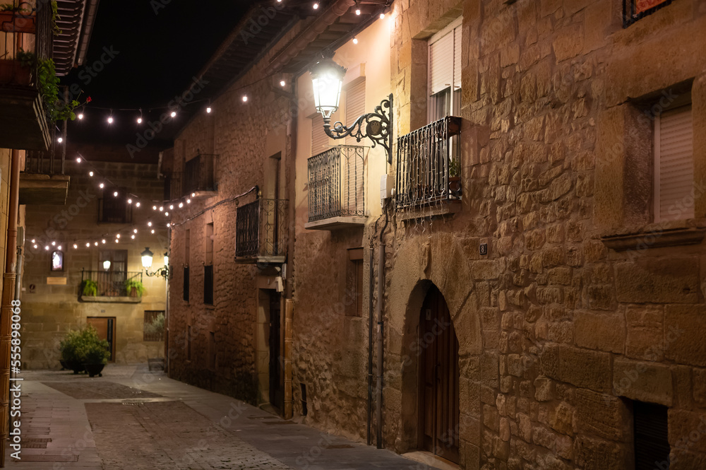 Walking at night on old medieval streets of Elciego village illuminated with Christmas lights, Rioja Alavesa, Spain