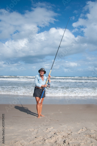 Old lady fishing on the beach