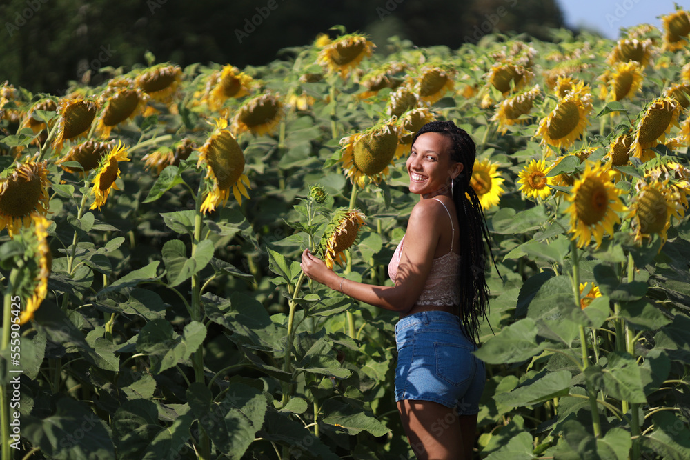 portrait of a happy young woman in a field with sunflowers portrait of a happy young woman in a field with sunflowers