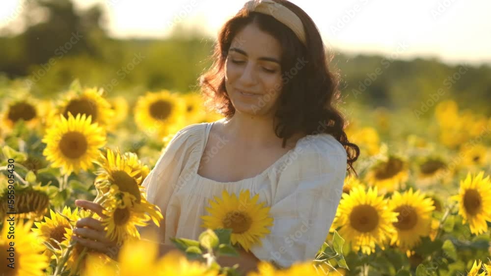 A young woman walks in a field of blooming sunflowers in summer. Food security, shortage of sunflower oil in the world. A young woman walks in a field of blooming sunflowers in summer. Food security, shortage of sunflower oil in the world.