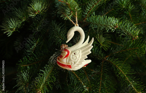 Christmas toy swan on a fluffy fir branch. Christmas wallpaper concept. Copy space. photo