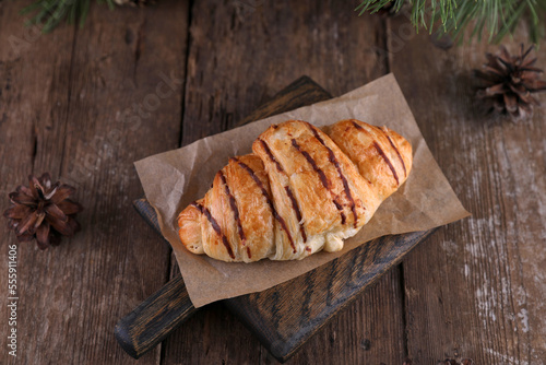 Croissant with chocolate on a wooden board on a wooden board