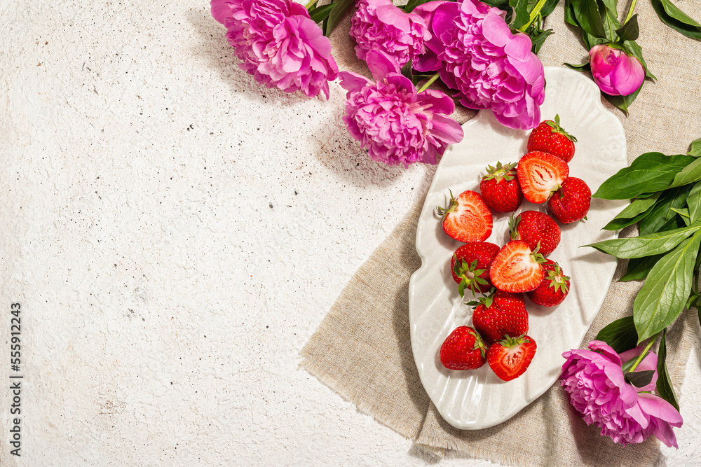 Sweet ripe strawberries and fragrant peonies bouquet. Summer plaster background, seasonal design Sweet ripe strawberries and fragrant peonies bouquet. Summer plaster background, seasonal design