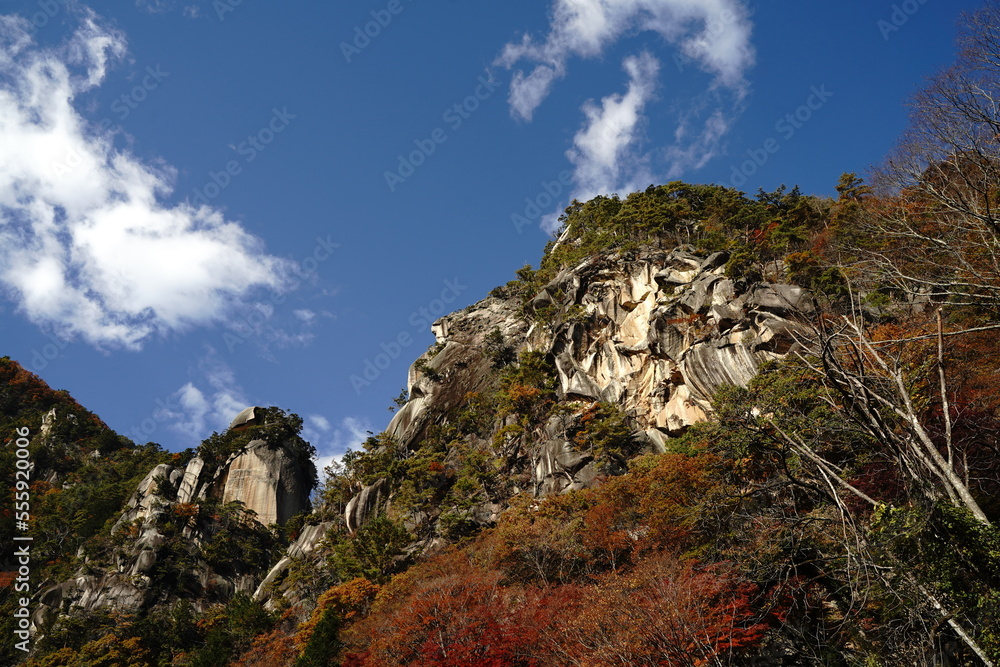 Obraz premium 昇仙峡、渓谷、岩山、岩、自然、紅葉、滝、水、川、流れ、葉、木、山、観光、旅行、日本、御岳昇仙峡、山梨県、しょうせんきょう、荒川、日本五大名峡、名勝、景色、風景、荒々しい、美しい、紅葉、赤い、葉、赤い葉、秋、11月、みたけ、覚円峰、巨岩、石門、花崗岩、甲府、こうふ、けいこく、ハイキング、マイナスイオン、空、野外、ツアー、木、大きい岩、青空、青、赤