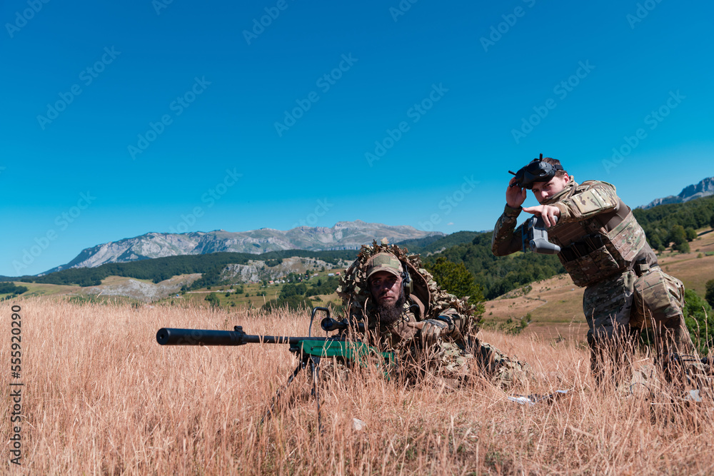 Sniper soldier assisted by an assistant to observe the area to be targeted with modern warfare tactical virtual reality goggles aerial drone military technology. Sniper soldier assisted by an assistant to observe the area to be targeted with modern warfare tactical virtual reality goggles aerial drone military technology.