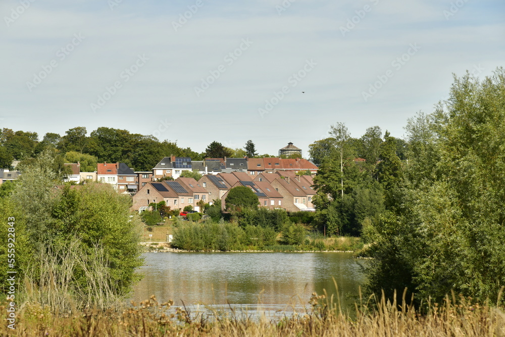 Le lac principal avec quelques lotissements résidentiels autour dissimulés derrière la végétation luxuriante du parc du Paradis à Braine l'Alleud en Brabant Wallon Le lac principal avec quelques lotissements résidentiels autour dissimulés derrière la végétation luxuriante du parc du Paradis à Braine l'Alleud en Brabant Wallon