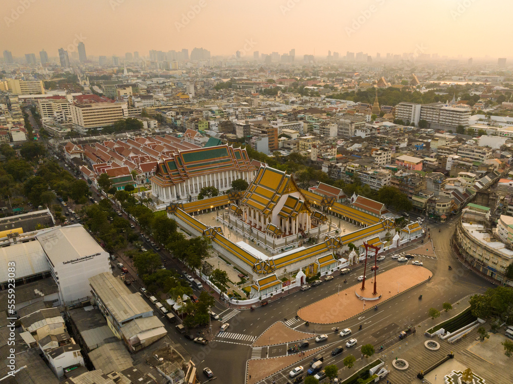 An aerial view of Red Giant Swing and Suthat Thepwararam Temple at sunset scene, The most famous tourist attraction in Bangkok, Thailand.