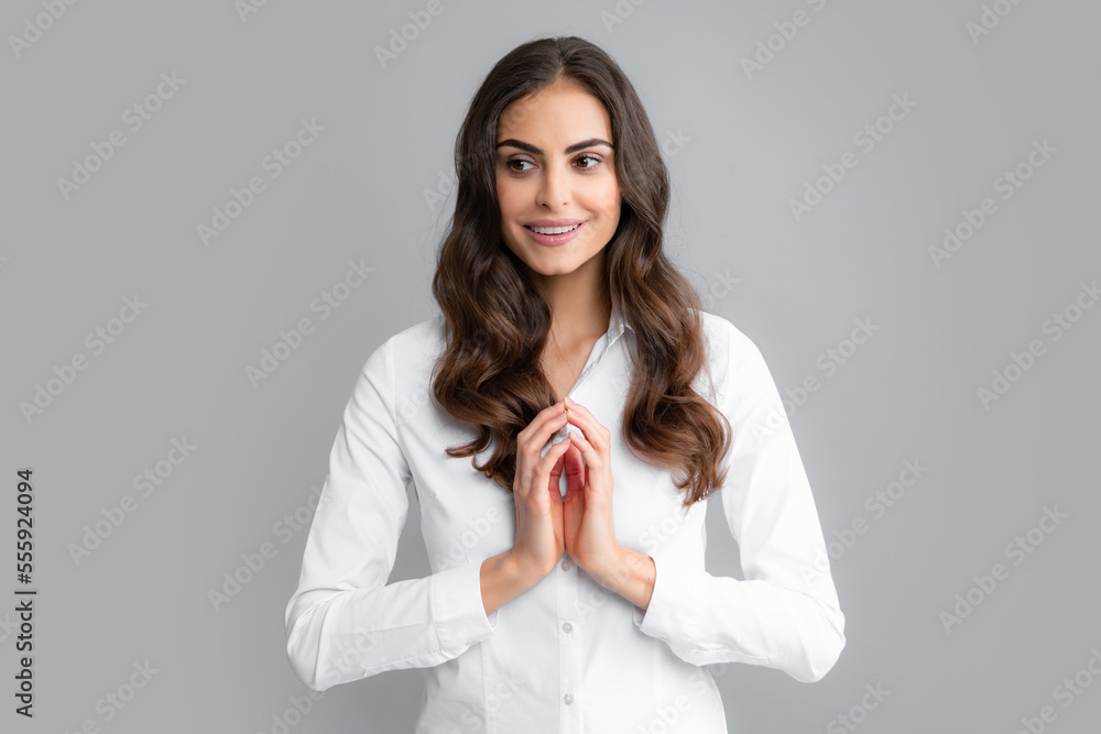 Pretty woman dressed casually in shirt looking with satisfaction. Studio shot of beautiful woman isolated against gray background. Pretty woman dressed casually in shirt looking with satisfaction. Studio shot of beautiful woman isolated against gray background.