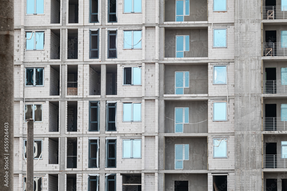 Multistory new residential white brick building facade construction site, architecture details pattern Multistory new residential white brick building facade construction site, architecture details pattern