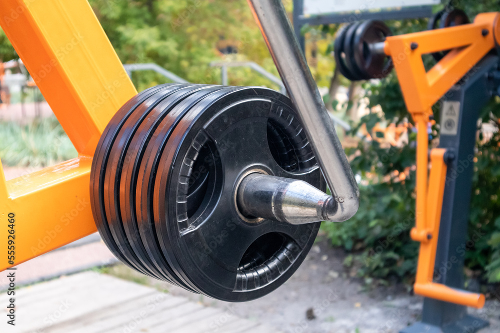 Round weights close-up on power exercise equipment. Outdoor sports ground with weight training details Round weights close-up on power exercise equipment. Outdoor sports ground with weight training details