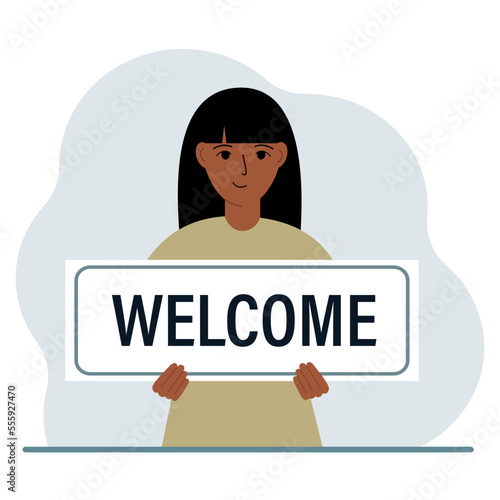 A woman holds in his hands a large sign, banner, postcard with the text Welcome.